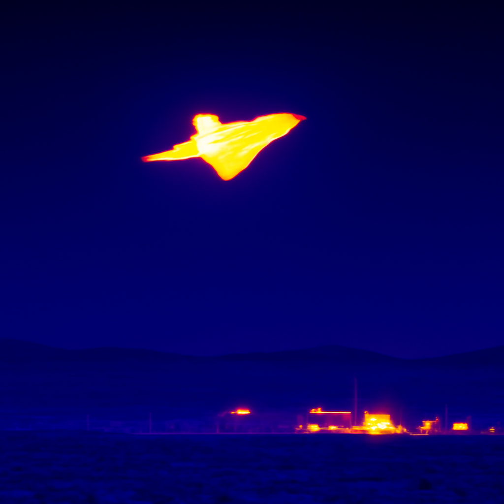 Nighttime thermal image of aircraft heat signature flying over Groom Lake facility.